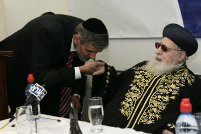 Shas leader kisses Rabbi Yosef's ring.